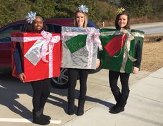 three girls are holding wrapped presents in front of a car