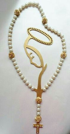 a rosary with an image of the virgin mary in gold and pearls, on a white background