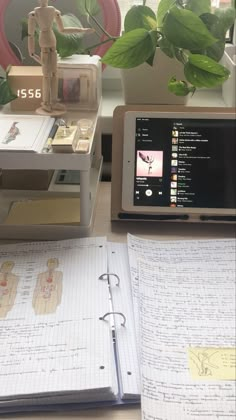 an open book sitting on top of a desk next to a computer monitor and keyboard