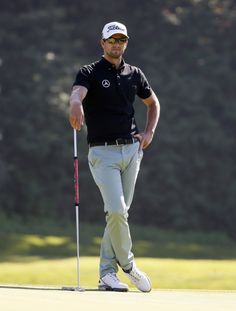 a man standing on top of a green golf course