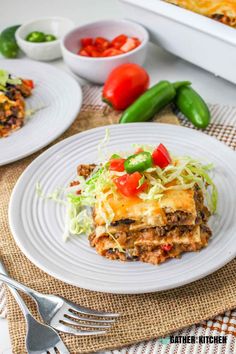 two plates with lasagna casserole on them, one has tomatoes and the other has green peppers