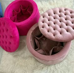 three pink and blue velvet foot stools sitting on top of a white rug next to each other