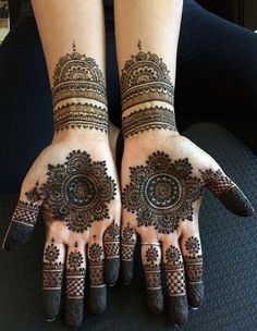 two hands with henna designs on them