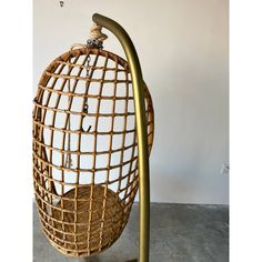 a rattan hanging egg chair on a metal stand