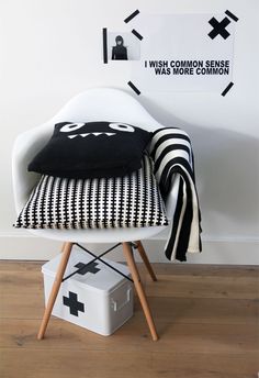 a white chair sitting on top of a wooden floor next to a black and white wall