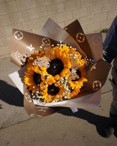 a bouquet of sunflowers and other flowers on the sidewalk