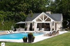 a pool house with an outdoor kitchen and dining area