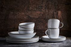 a stack of white cups and saucers sitting next to each other on a table