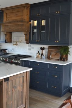 a large kitchen with blue cabinets and white counter tops, wood accents on the backsplash