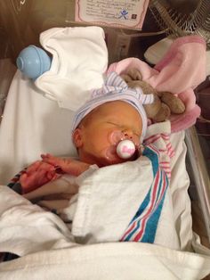 a baby in a hospital bed with a pacifier