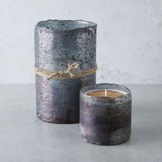 two gray candles sitting next to each other on a table