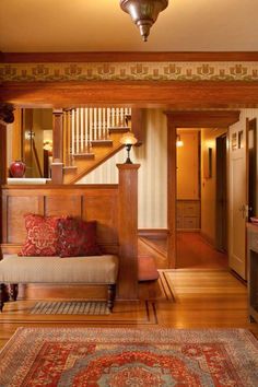 an image of a living room with stairs and rugs on the floor in front of it