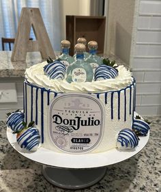 a cake decorated with blue striped strawberries and bottles of donutjullo vodka