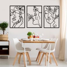 a dining room table with chairs and artwork on the wall