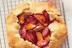 a close up of a pie on a cooling rack with fruit in the crust and toppings