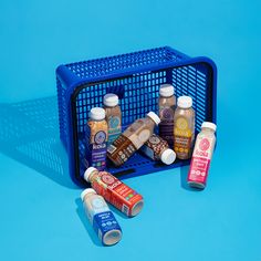 an assortment of condiments sitting in a blue basket on a blue surface with the lid open