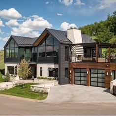 a large modern house with lots of windows on the front and side of it's roof