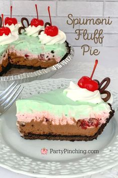 two pieces of pie with cherries and whipped cream on top