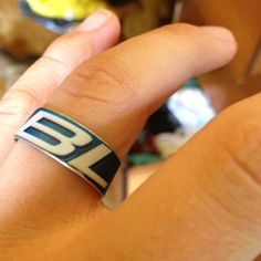 a person wearing a ring with the letter b on it