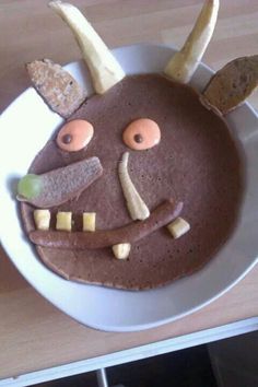 a plate with a face made out of chocolate and banana peels on top of it