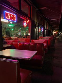 an empty restaurant with red booths and neon signs