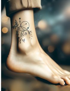 a close up of a person's foot with a flower tattoo on the ankle