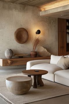 a living room filled with white furniture and large vases on top of the tables