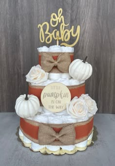 a three tiered diaper cake with pumpkins and burlocks on top