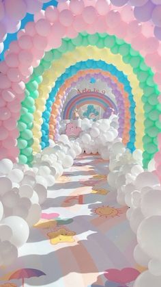 an image of a rainbow colored tunnel with balloons on the floor and unicorns in the background