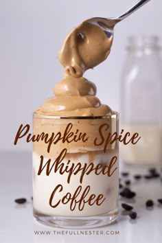 pumpkin spice whipped coffee in a glass jar with a spoon sticking out of the top