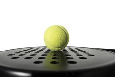 a tennis ball sitting on top of a racket