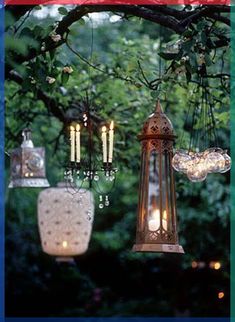 an image of some lights hanging from a tree in the yard with candles on it