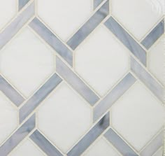 a white and blue tiled wall with an interesting design