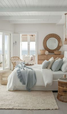 a white bedroom with wicker furniture and an ocean view