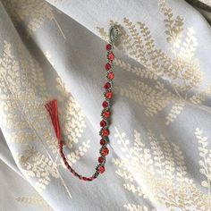 a red beaded necklace on a white fabric