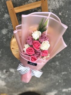 pink and white roses are wrapped in cellophane to look like they have been tied together