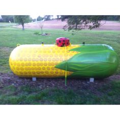 a large inflatable boat with a ladybug on it sitting in the grass