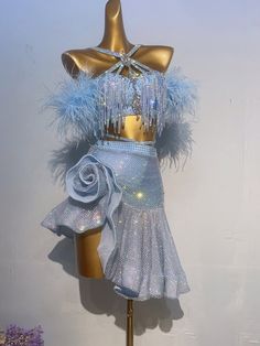 a mannequin dressed in blue and silver with feathers