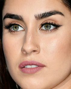 a close up shot of a woman's face with long lashes and pink lipstick