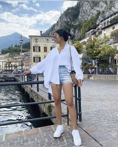 a woman standing next to a body of water