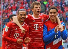 three soccer players are posing for a photo in front of an audience at a sporting event