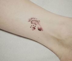 a small foot with a bear paw tattoo on the left side of the leg,