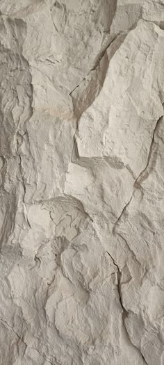 a white rock wall with some cracks in it