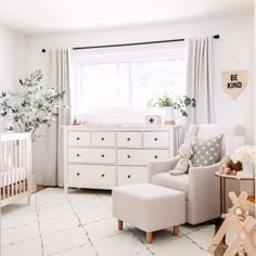 a baby's room with white furniture and decor