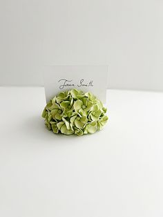 a white card with some green flowers on it