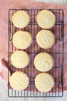 four cookies cooling on a wire rack next to a red and white checkered napkin