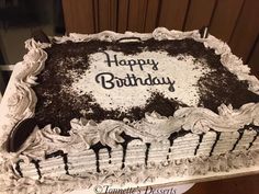 a birthday cake with chocolate frosting and white icing on the top that says happy birthday