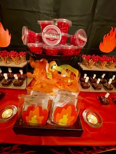 a table topped with lots of candy and candies on top of a red table cloth