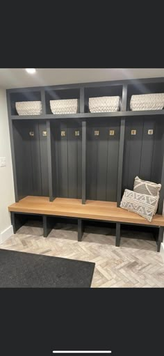 an empty bench in the middle of a room with some baskets on top of it