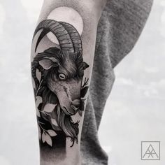 a man with a goat head tattoo on his arm